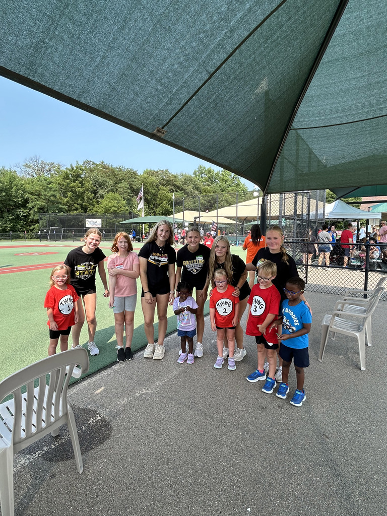 A large group of children with Gretna East High School softball players outside