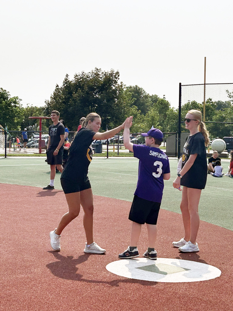 Gretna East High School softball player giving a high five to a AllPlay on base