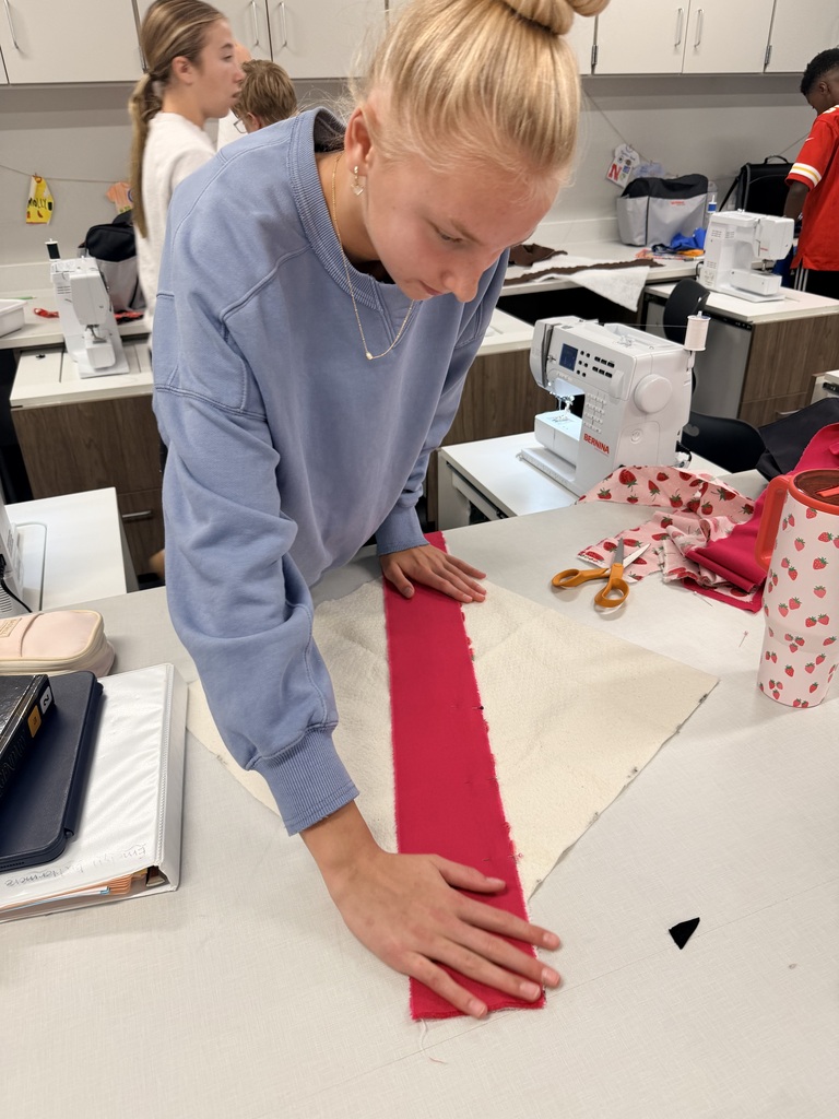 Student cutting out fabric.