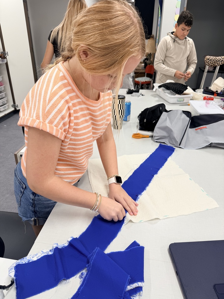 Student cutting out fabric.