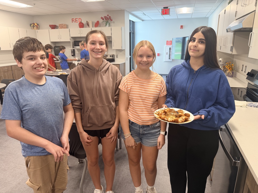 Four students smiling at the camera.