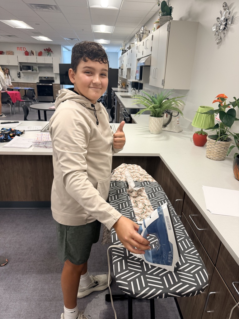 Student smiling and ironing.