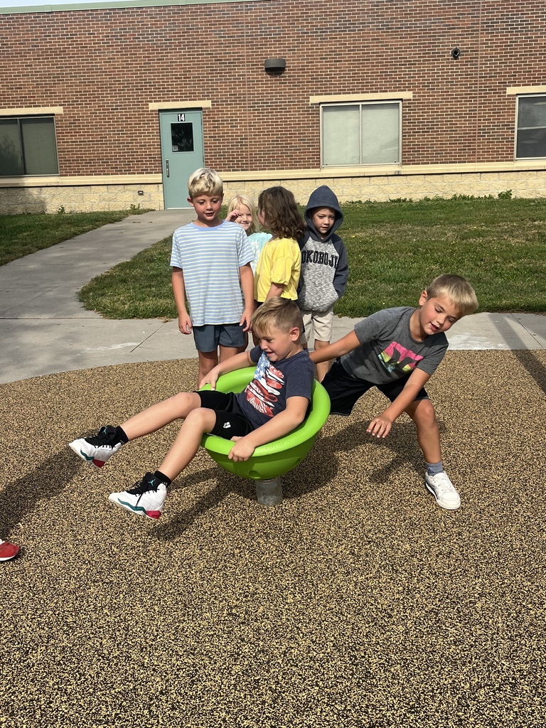 Students spinning each other outside in a spinner bowl 