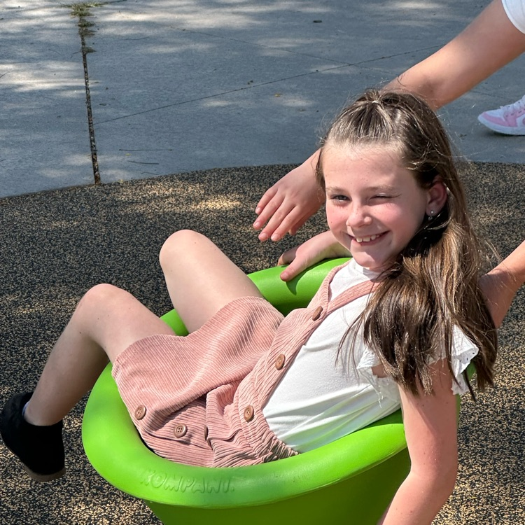 child on green playground spinner 