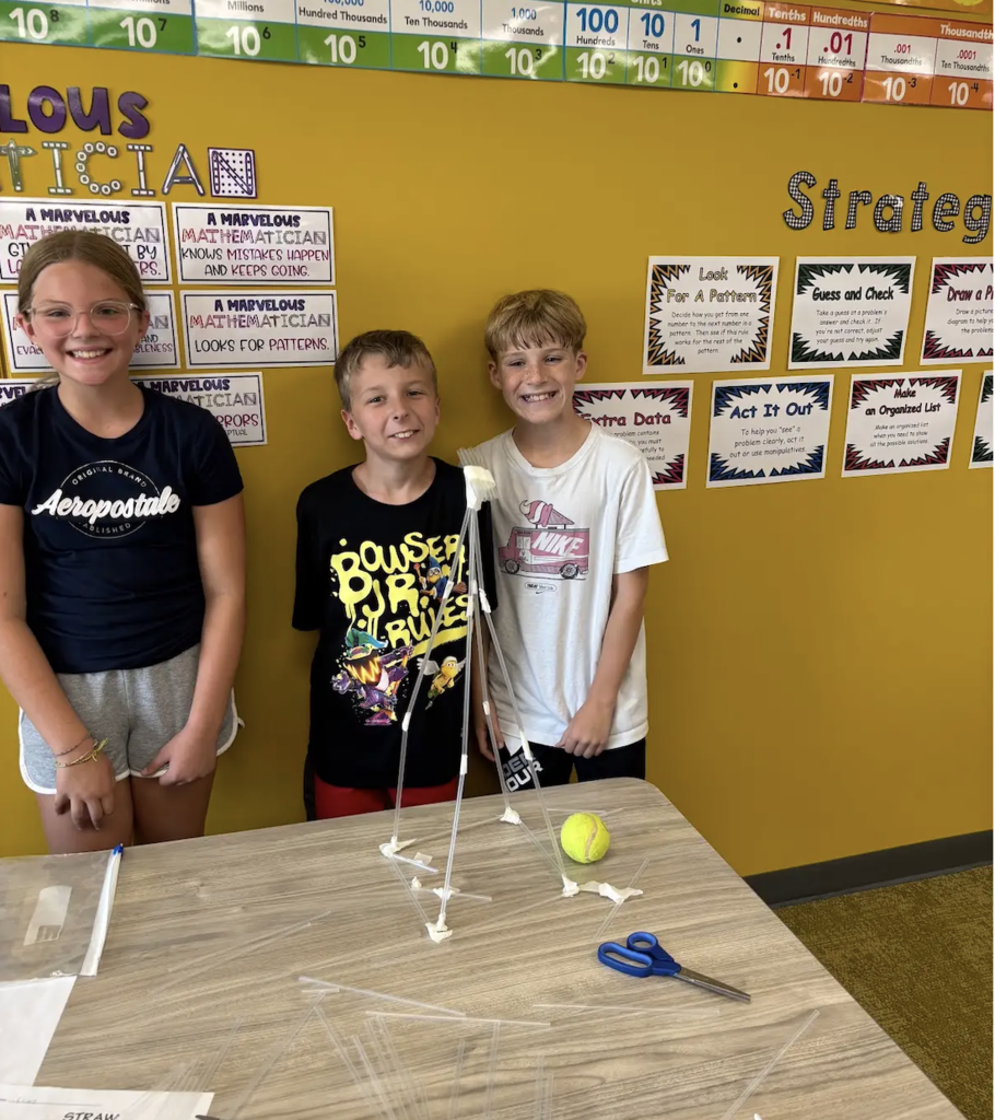 students smiling with a stem project completed 