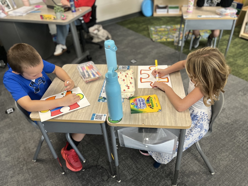students working on a puzzle piece coloring project in a classroom at desks