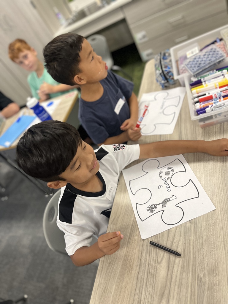 students seated working on a project in a classroom at a table