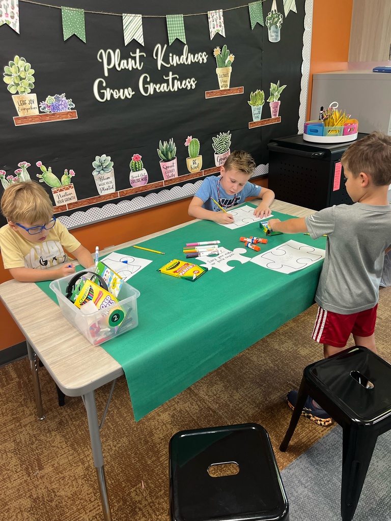 students working on a puzzle project coloring in class