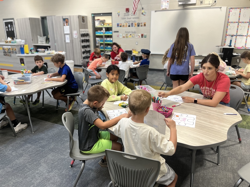 students working on a project in the library with staff
