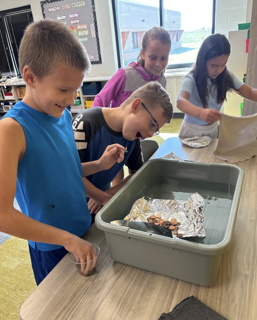 students working on a floating boat with pennies as a STEM project