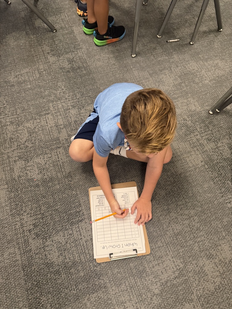 students taking a survey in a classroom with clipboards on the floor