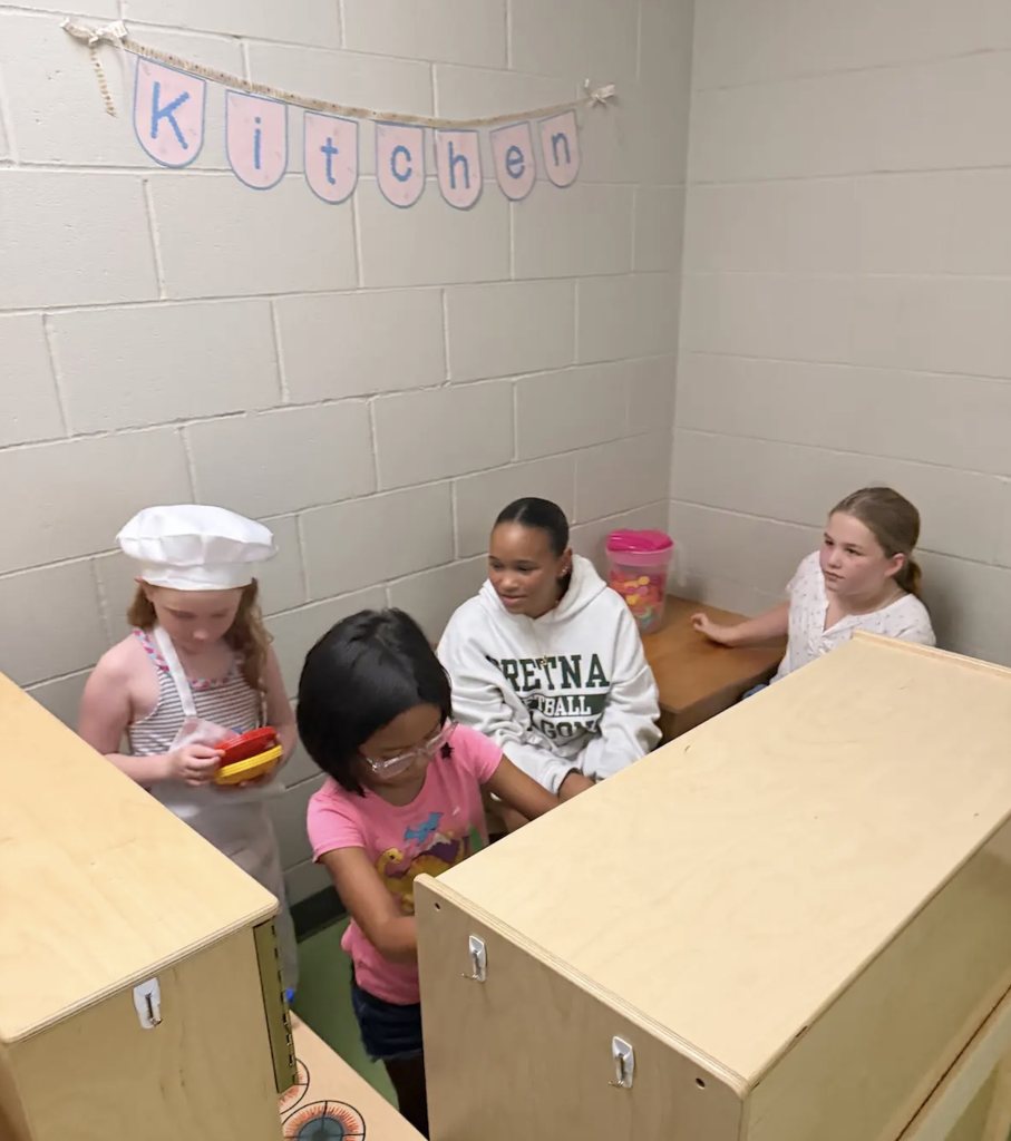 students playing in a kitchen center 