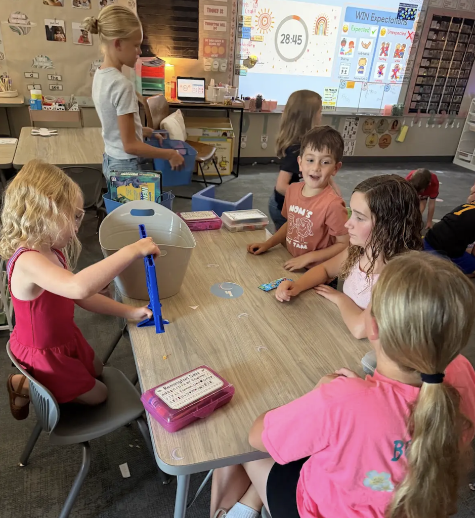 students preparing to play connect 4 together in a classroom