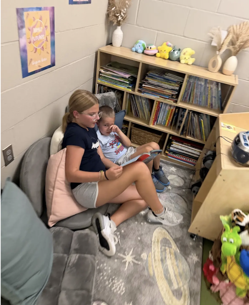 an older student reading to a younger student