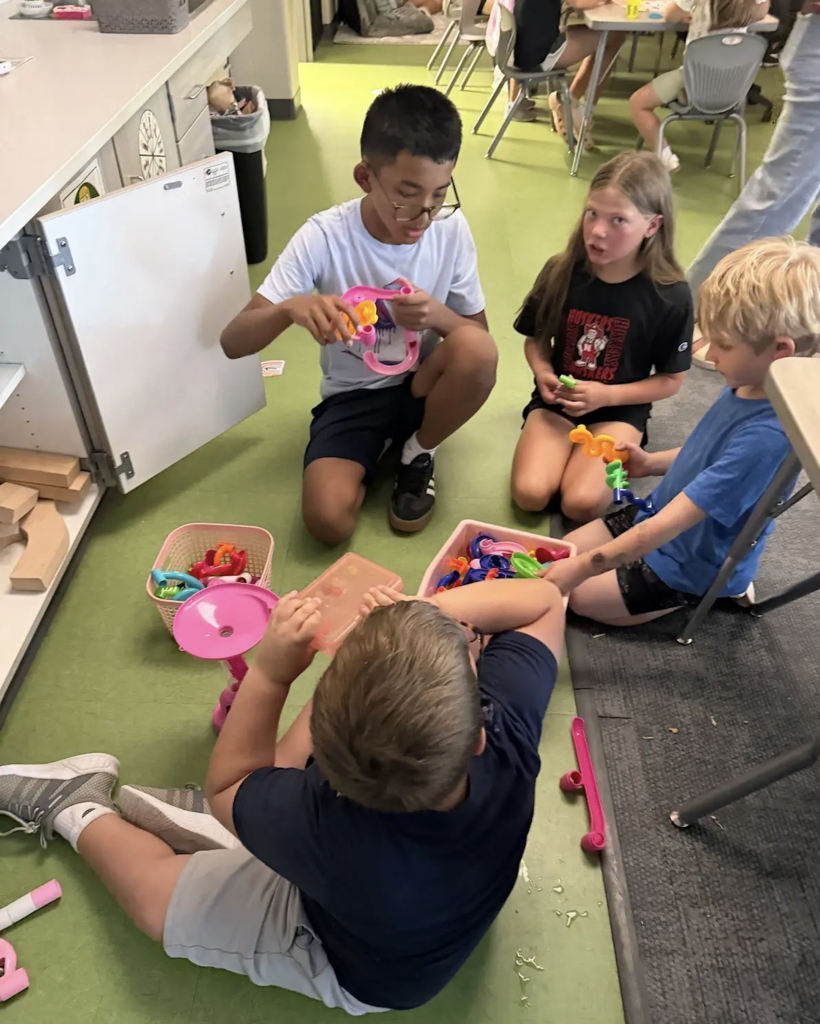 students playing marble run together in a classroom