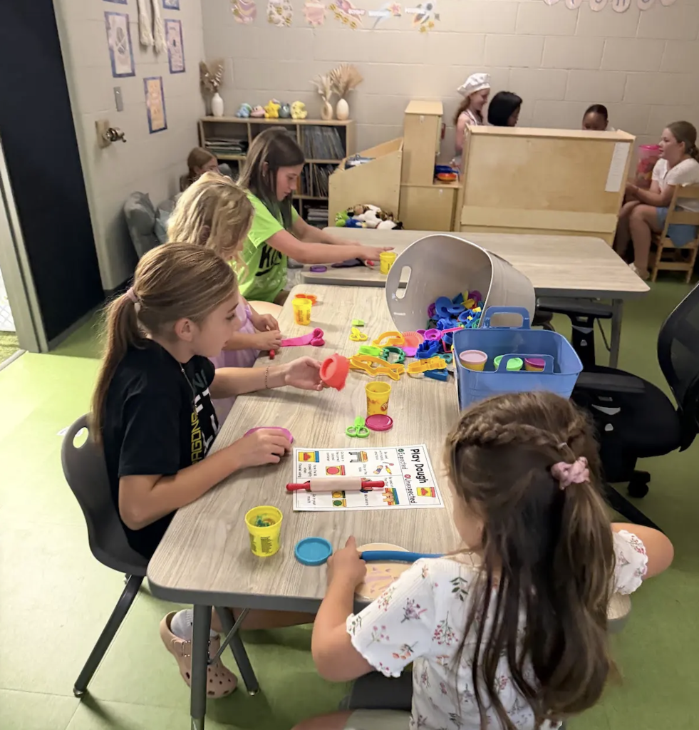 students playing playdoh in a classroom with their buddies from 5th grade.