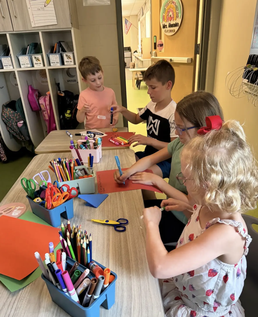 students playing in an art center together in a classroom