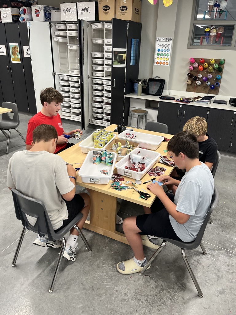 8th grade students working on their pop can sailboats during art class