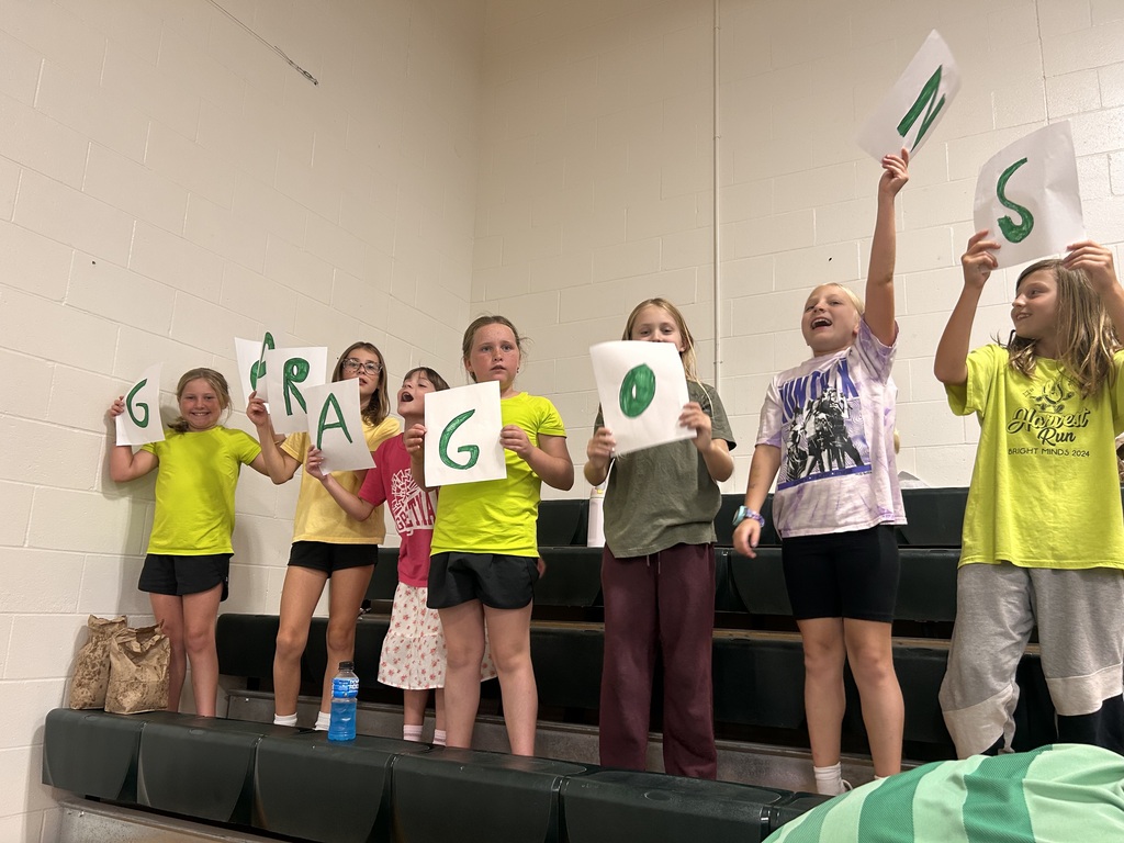 kids holding 'go dragons' signs