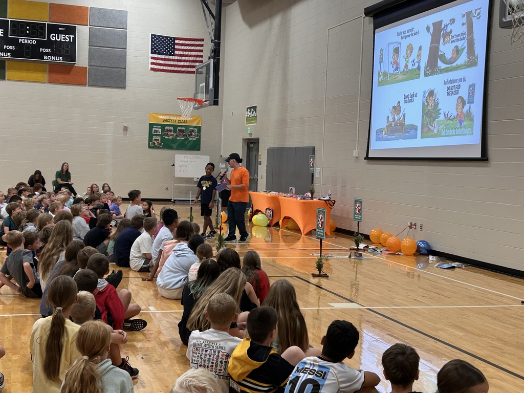 author providing a book talk with students in a gym