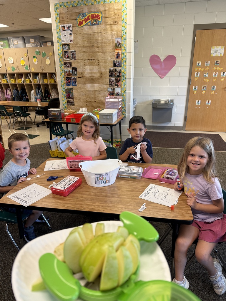 Four students are completing an activity about parts of an apple.