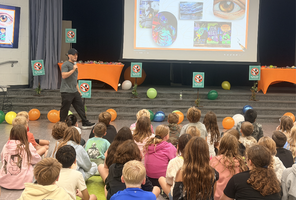 Justin welcomes the 4th and 5th grade students to his presentation with a little balloon party!