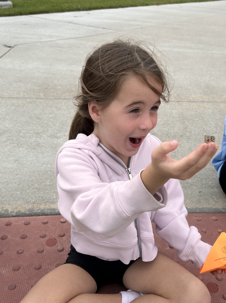 student holding a butterfly for release