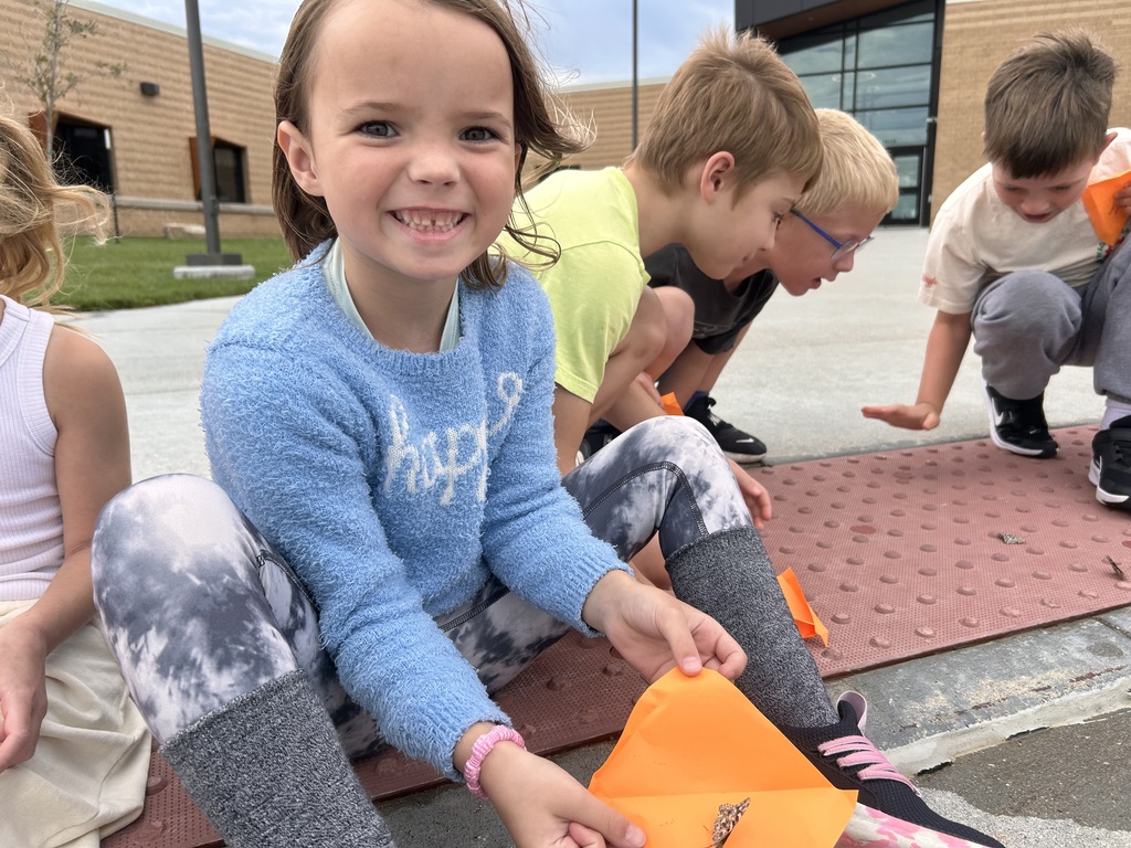 student holding a butterfly for release