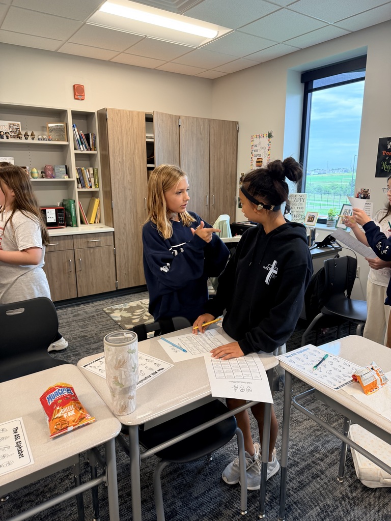 Two students are practicing ASL. 