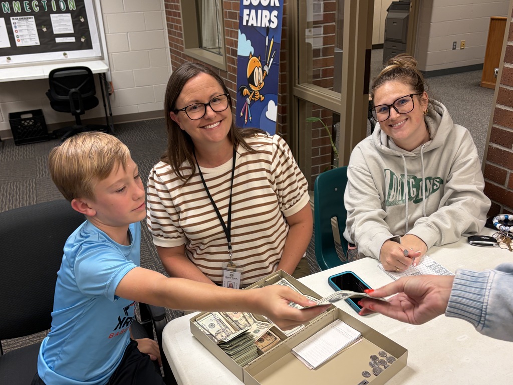 TES staff members taking money at the pancake man in the cafeteria.