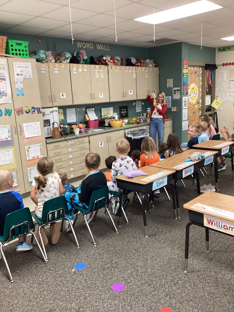First grade students looking at an apple peeled. It is spiraled.. 