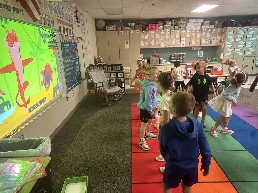 Students are watching a video and dancing.