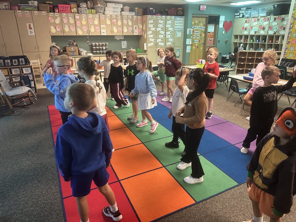 Students are dancing on a rug.