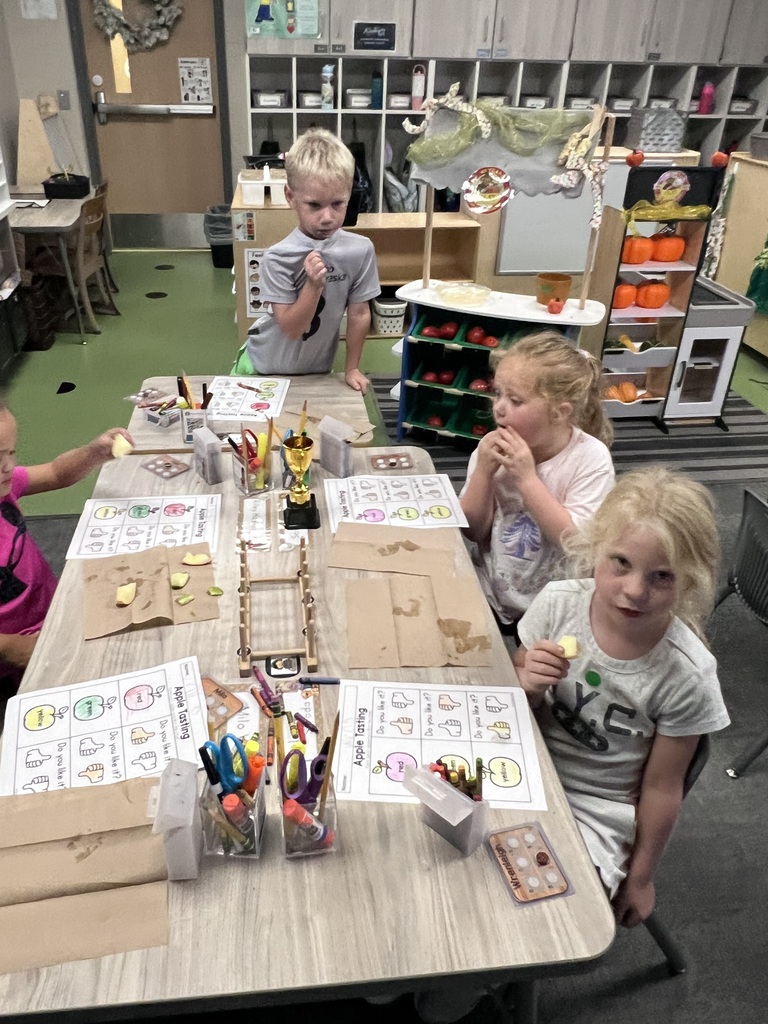 students apple tasting in class. in front of them they have an apple tasting sheet to show if they liked or disliked the apple