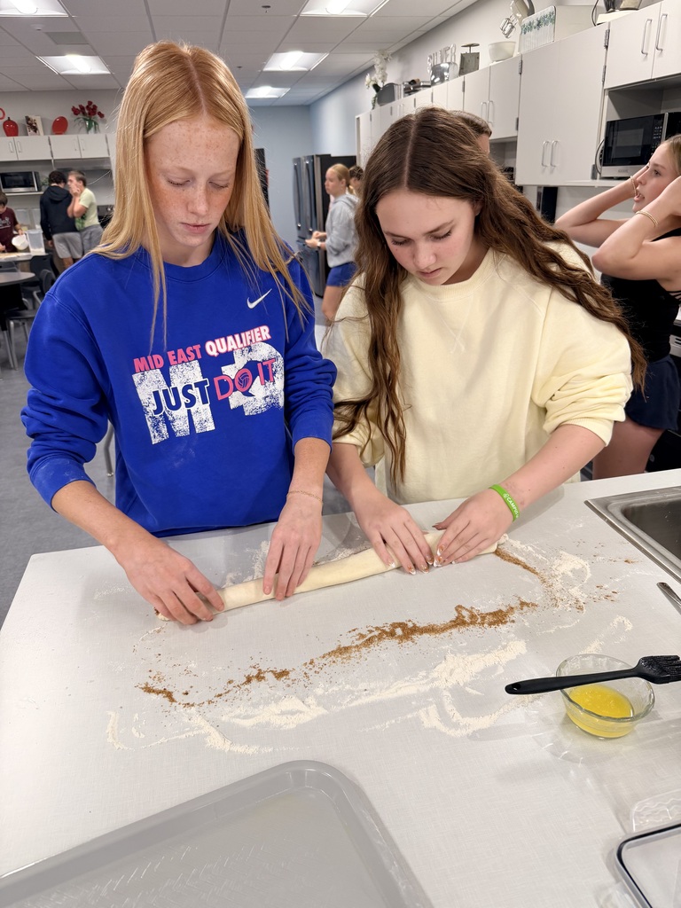 Two female students are making cinnamon rolls. 