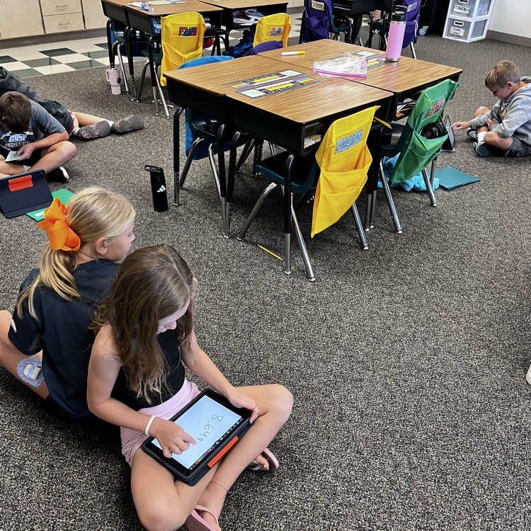 kids working back to back using iPads
