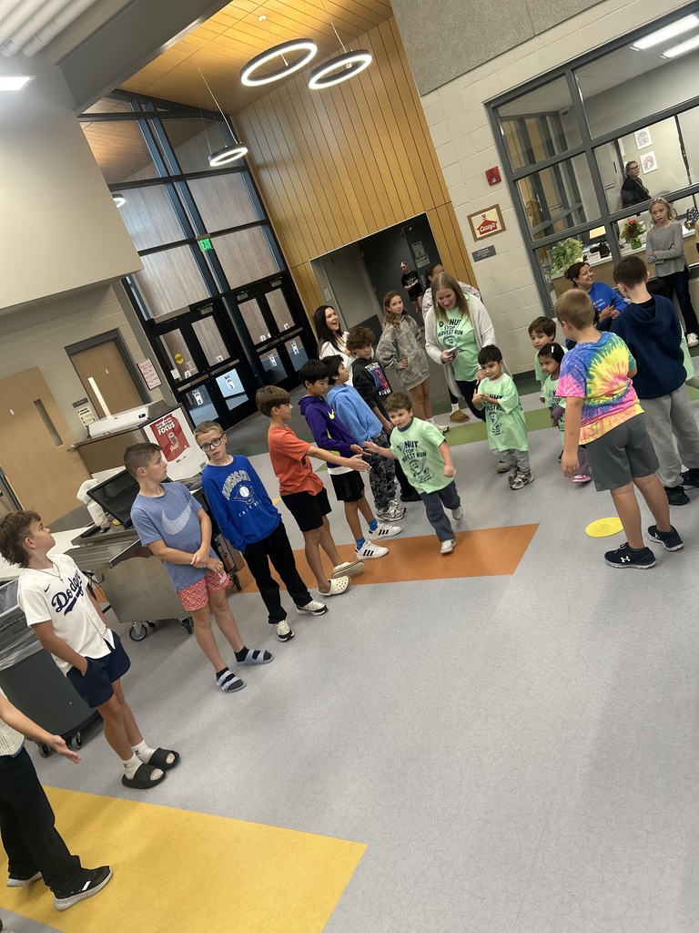 students shaking hands while they go through the harvest run in the cafeteria