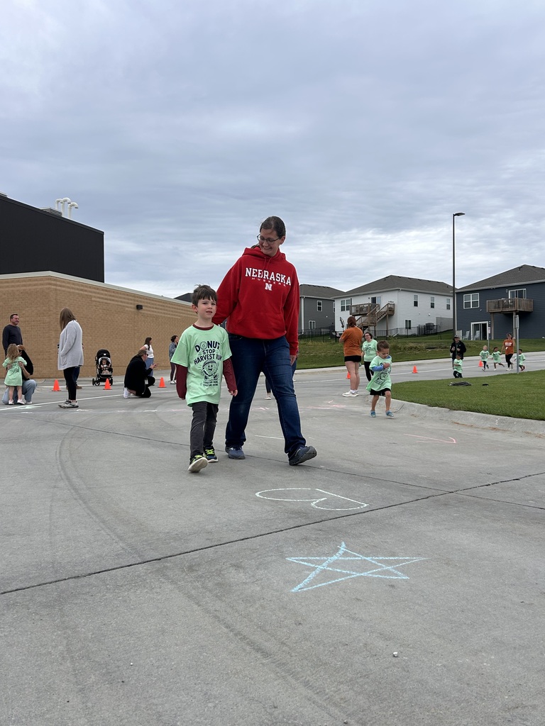 a parent walks with their child at the school fun run outside
