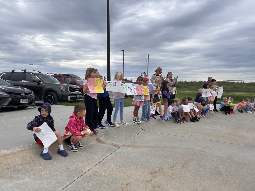 a cheering section cheers on the harvest run students with signs they made