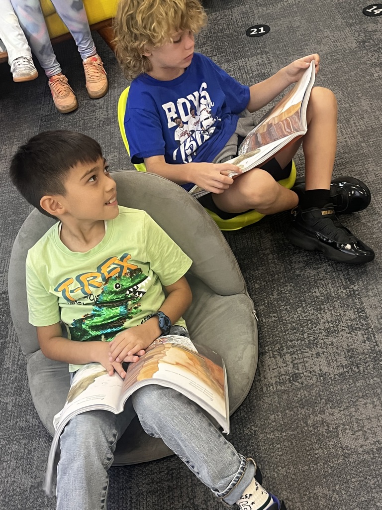 two boys sitting in flexible seating reading a story together
