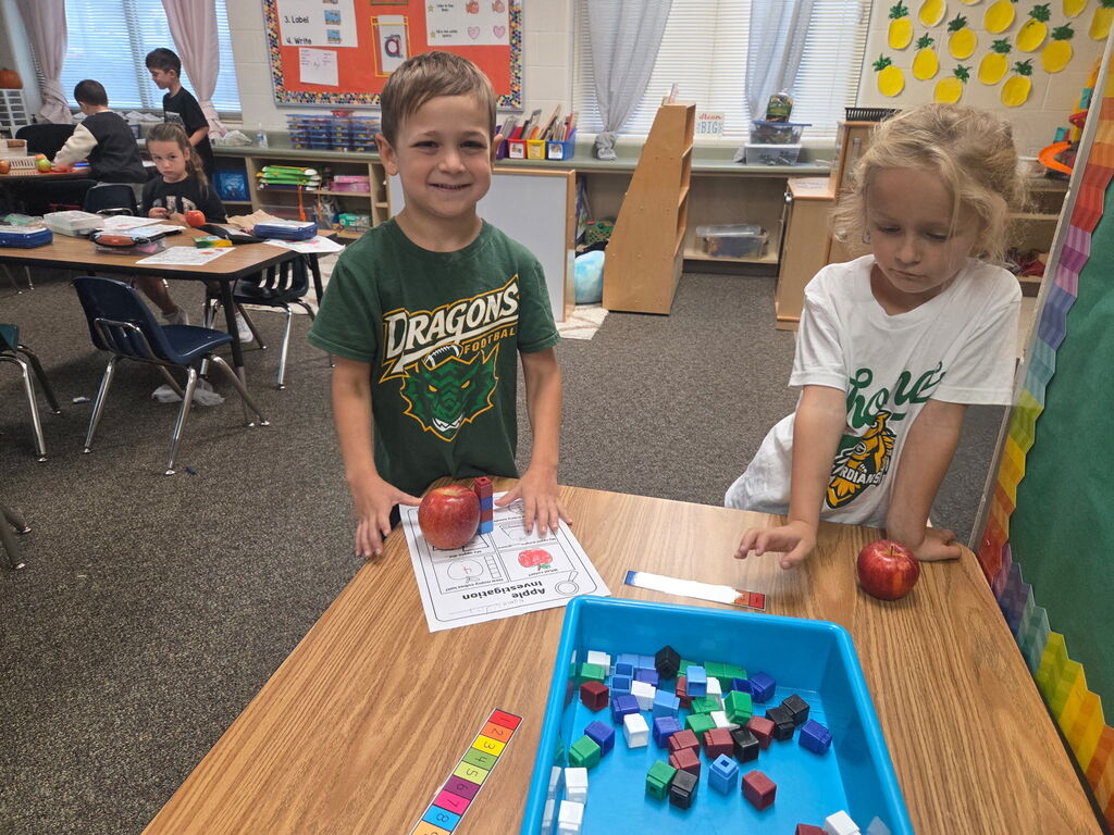 Two students work on apple explorations at their table.