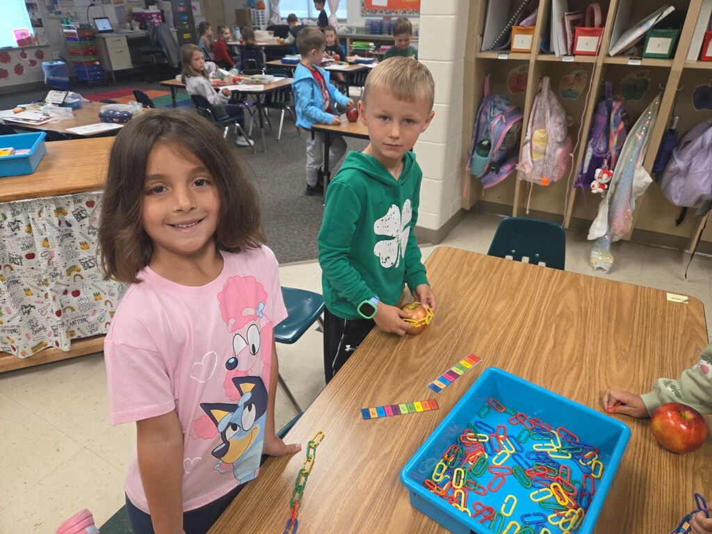 Two students work on apple explorations at their table.