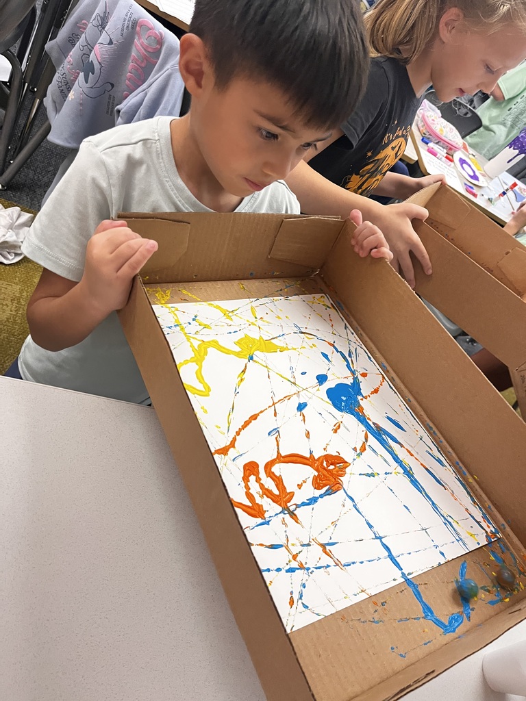 a student works on a marble painting project in class