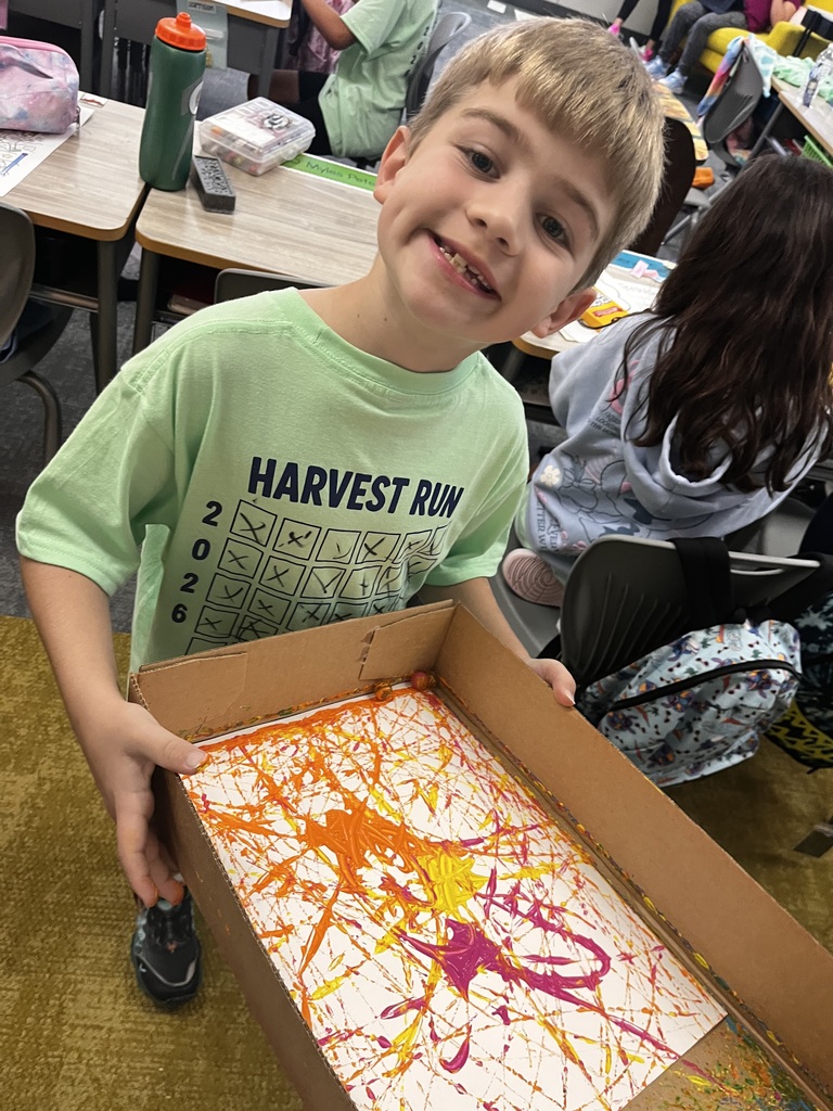 student working on a marble painting project in class using a cardboard box