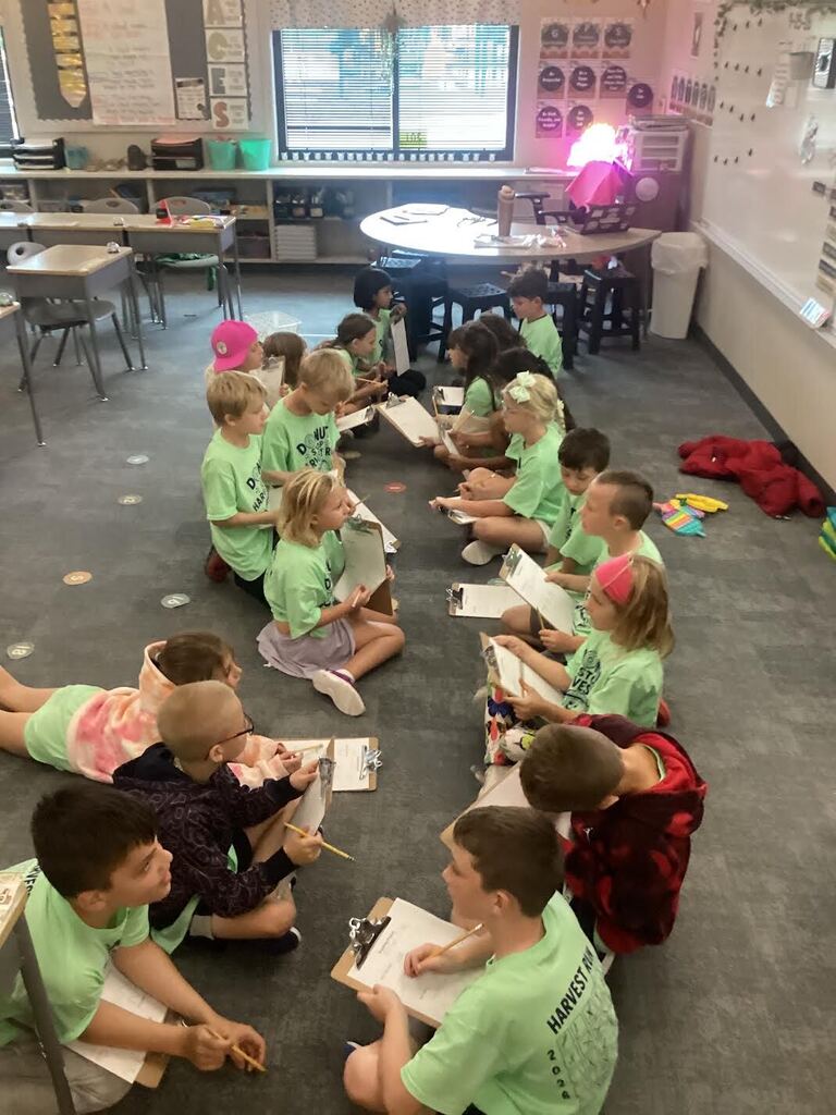 students seated on the carpet in a classroom working on data collections