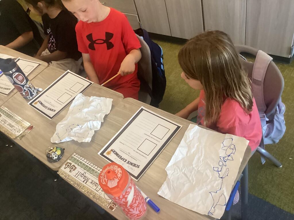 students are working on their science papers at their seats.