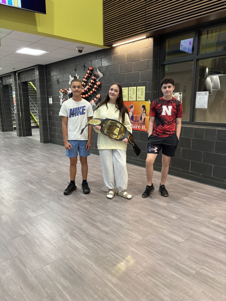 8th graders at ACMS hold the belt while celebrating winning the moment.