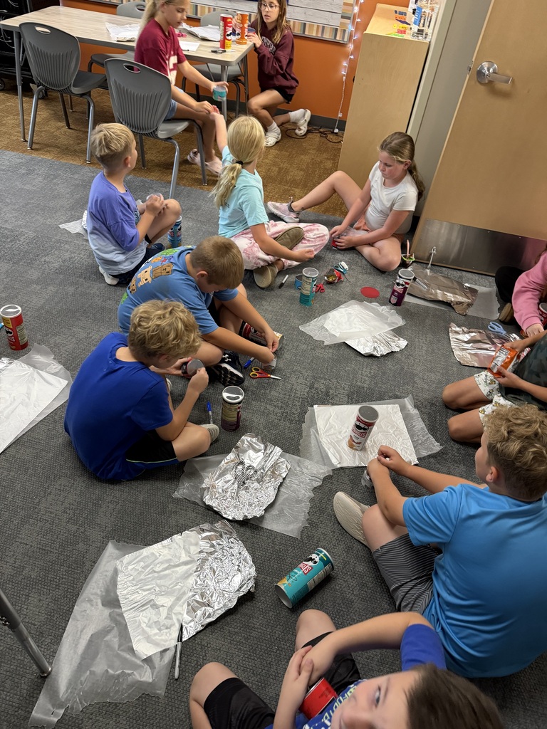 students working on a project on the floor in their classroom
