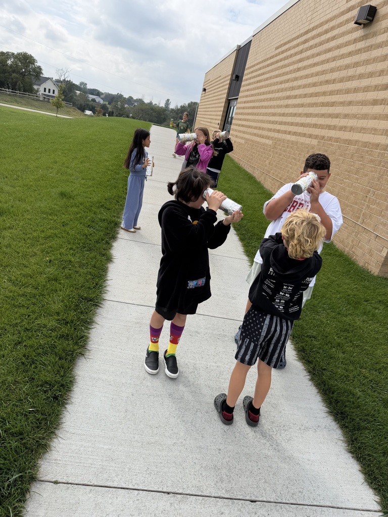 students looking through a pinhole camera outside