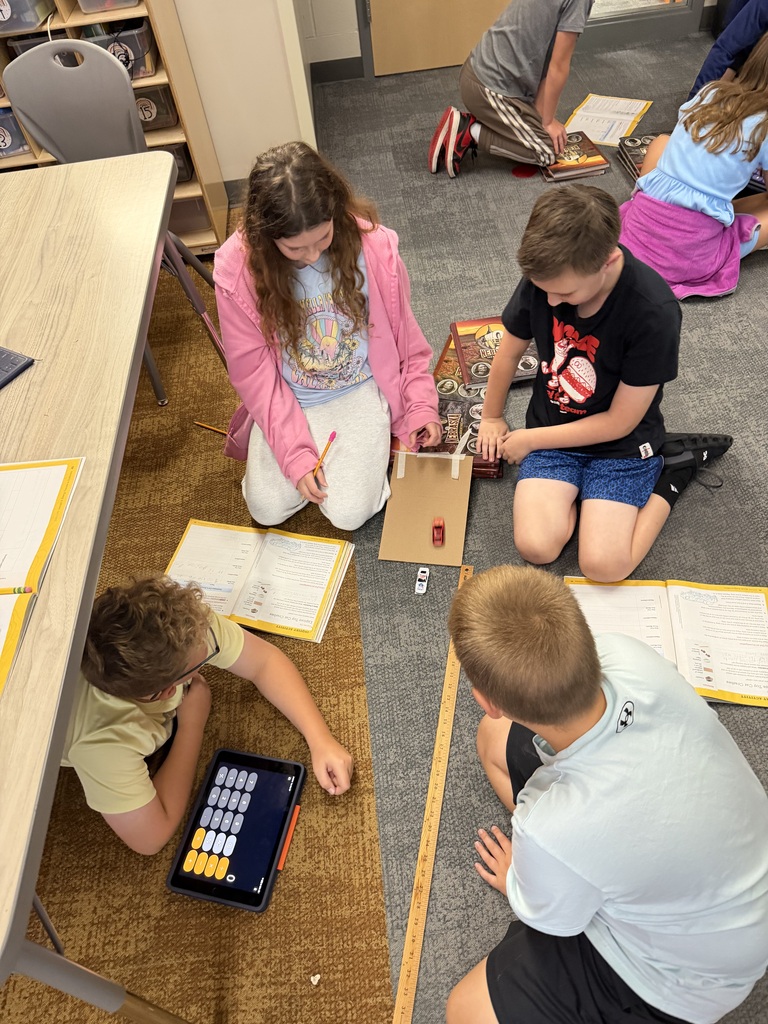 students working on a science lab with a ramp and cars